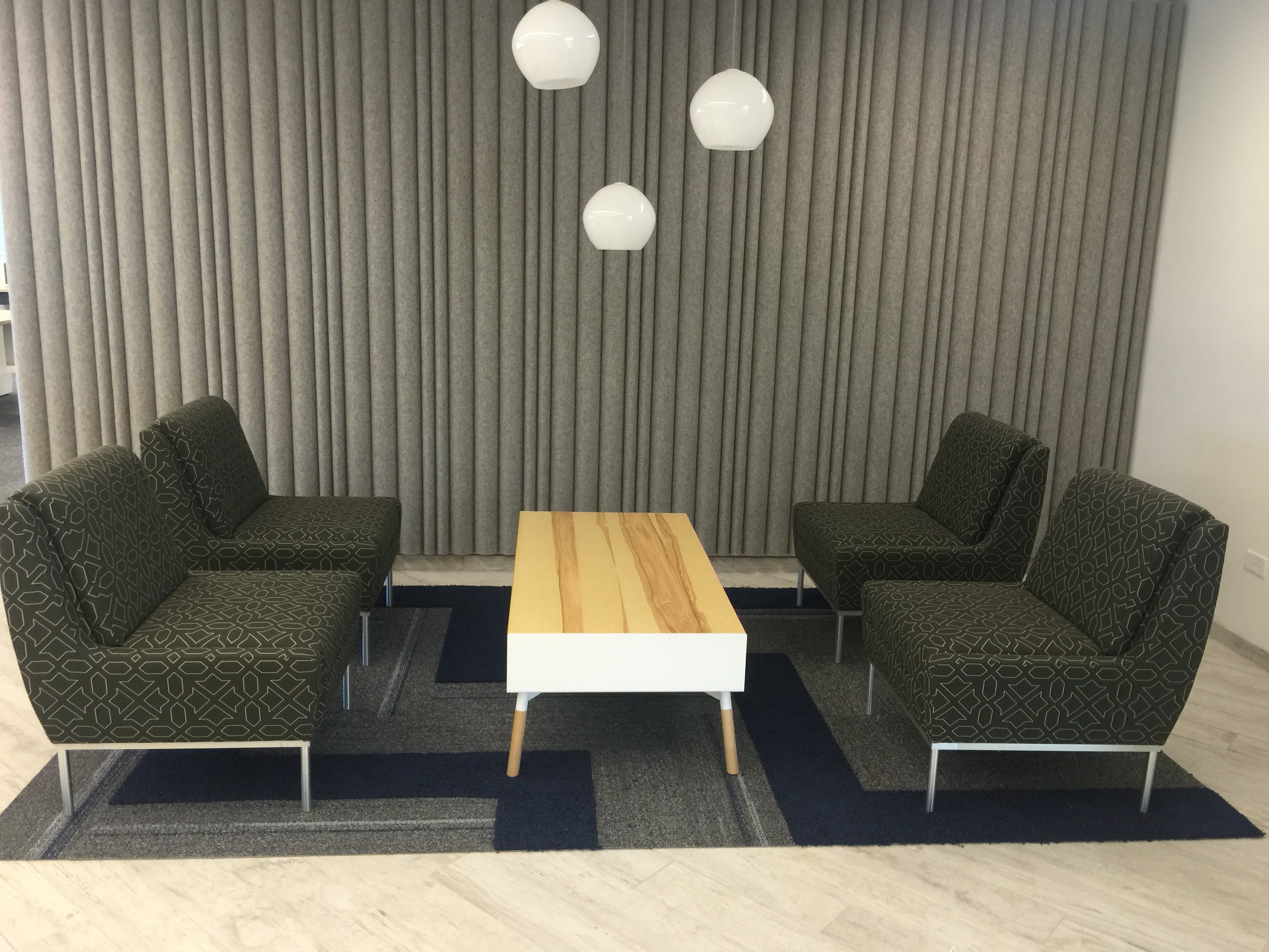 Collaborative space featuring seating, table, and lighting